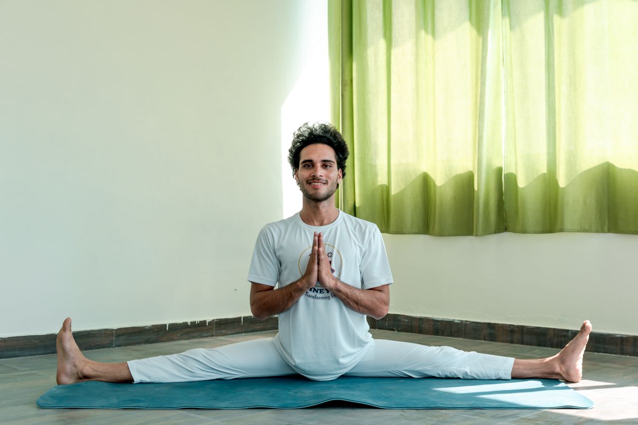 who-we-are Man practicing yoga indoors with a calm and focused expression, highlighting flexibility and mindfulness.